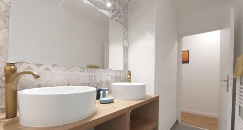 un bagno con due lavandini e uno specchio di Groix a Lorient
