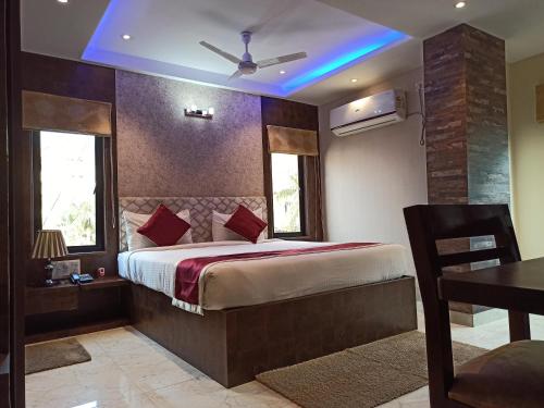 a bedroom with a large bed with a blue ceiling at Hotel A P Home's - A Boutique Hotel in Guwahati