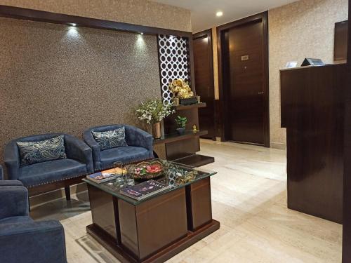 a lobby with a waiting room with blue chairs and a table at Hotel A P Home's - A Boutique Hotel in Guwahati