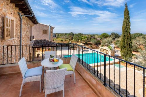 a balcony with a table and chairs and a pool at S'Hort Can Capità in Ariany