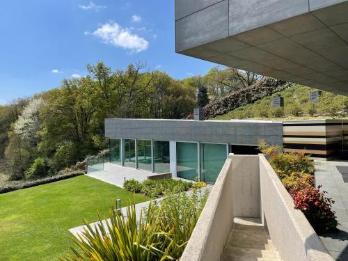 a modern house with a garden in front of it at Tres Prismas Exclusive in Sarria
