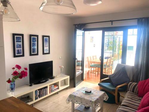 a living room with a couch and a tv at Casa Joe, cosy one bedroom apartment on popular complex with pool in Tías