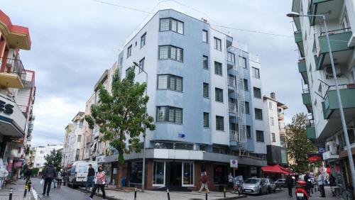 a tall blue building on a busy city street at ÇALIŞKANLAR OTEL in Canakkale