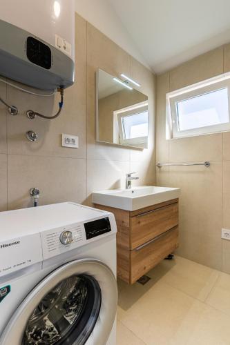 a washing machine in a bathroom with a sink at SALVIA in Cres