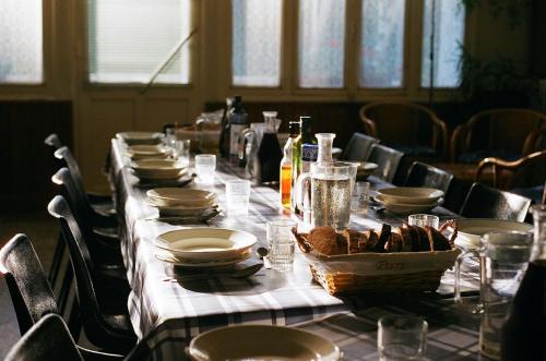 - une grande table avec des assiettes et des bouteilles de vin dans l'établissement L'Etoile Maison d'hôtes Demi-pension, à La Bastide-Puylaurent