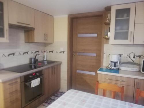 a kitchen with wooden cabinets and a counter top at Kwatera Na Rogu in Augustów