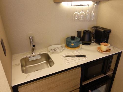 a kitchen counter with a sink and a coffee maker at Tokyu Stay Hakodate Asaichi Akarinoyu in Hakodate