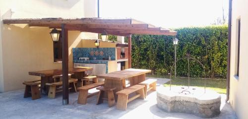 an outdoor kitchen with wooden tables and benches at Ville dell'Eden con 9 camere da letto in 6 unità abitative in Lascari