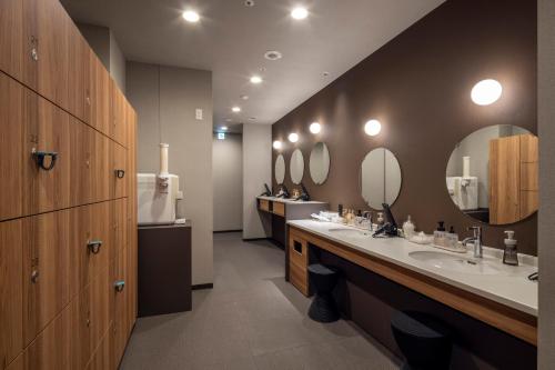 a bathroom with two sinks and two mirrors at Tokyu Stay Hakodate Asaichi Akarinoyu in Hakodate