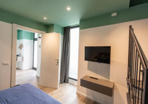 ein Schlafzimmer mit einem Bett und einem TV an der Wand in der Unterkunft TwoWays5Terre in La Spezia