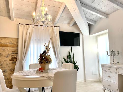 a dining room with a table and a chandelier at Dimora di Charme Rooms & Apartments in Peschiera del Garda