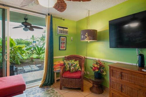 a room with green walls and a chair and a television at OUTSTANDING OCEANFRONT STUDIO - KONA ISLANDER INN CONDOS condo in Kailua-Kona