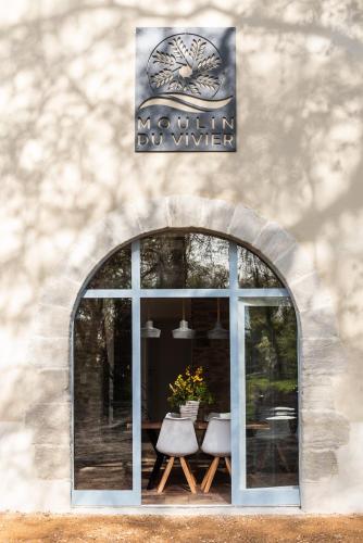 a window of a building with a table and chairs at LE MOULIN DU VIVIER in Saint-Martin-Lalande