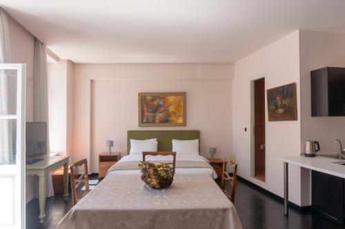 a bedroom with a bed with a bowl of fruit on a table at Afrodite's Mansion in Plaka by JJ Hospitality in Athens