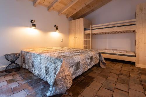 a bedroom with a bed and bunk beds at LE MOULIN DU VIVIER in Saint-Martin-Lalande