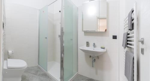 een witte badkamer met een toilet en een wastafel bij Brand New Studio with Garage - Close to the Beach in Acquarica del Capo