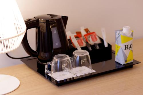 a coffee maker and glasses on a tray on a table at Sercotel Carlos III in Cartagena