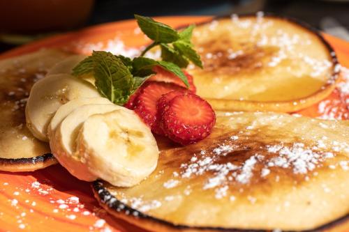 a plate of pancakes with bananas and strawberries at Hotel Milu Florence in Florence