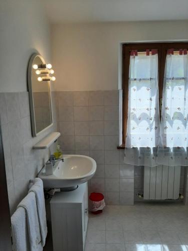 a bathroom with a sink and a mirror and a window at Il Corbezzolo in Paciano