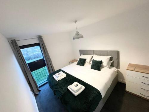 a bedroom with a bed with two towels on it at BEST PRICE! Huge 1 bed Apartment, City Centre, Single Beds or Super King, Sofabed & FREE SECURE PARKING in Southampton