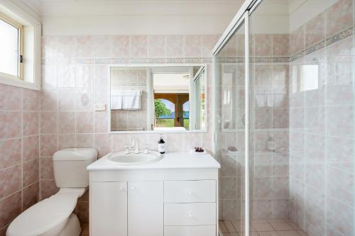 a bathroom with a toilet and a sink and a shower at South Coast Retreat in Greenwell Point
