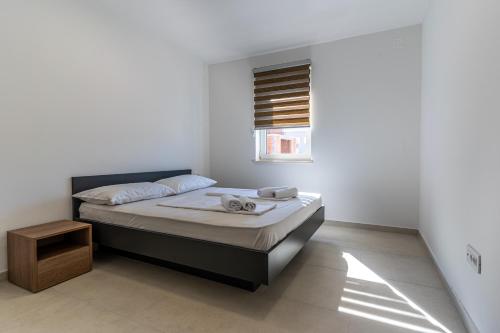 a bedroom with a bed and a window at Sunset Apartment in Cres