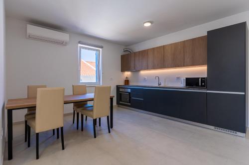 a kitchen and dining room with a table and chairs at Sunset Apartment in Cres