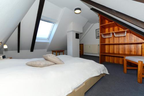ein Schlafzimmer mit einem weißen Bett und einer Holzwand in der Unterkunft Haus Albatros Whg 04 in Wyk auf Föhr