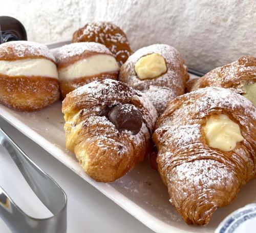 un vassoio di dolci e ciambelle su un tavolo di B&B La CYCAS a San Vito lo Capo