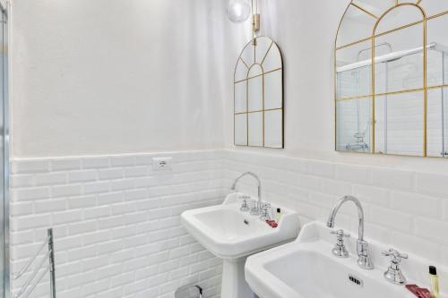 a white bathroom with two sinks and a mirror at Maison d'Orange - La Pinede in Saint-Tropez