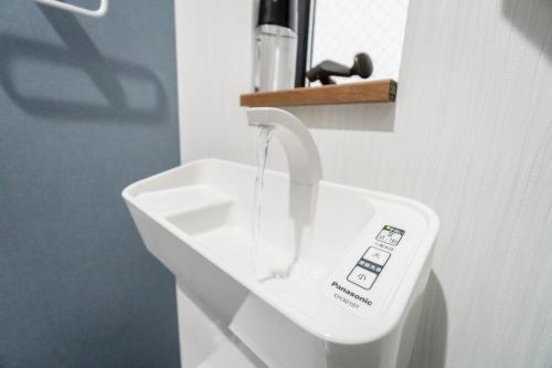 a bathroom with a white sink with a faucet at HANASTAY花渓居 · 海（UMI) in Osaka