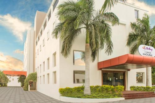 a building with a palm tree in front of it at Sterling V Grand Madurai in Madurai