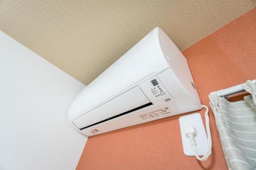 a white printer sitting on a table next to a bed at HANASTAY花渓居 · 海（UMI) in Osaka
