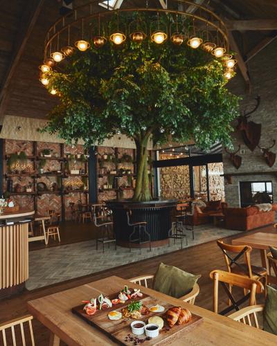 ein Esszimmer mit einem Baum und einem Tisch mit Essen in der Unterkunft DOR in Bran