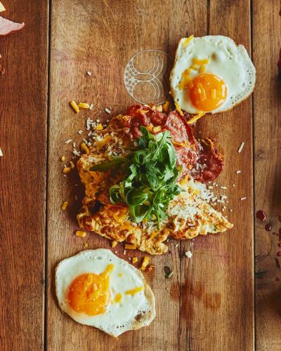 ein Holztisch mit Eiern auf einer Pizza in der Unterkunft DOR in Bran