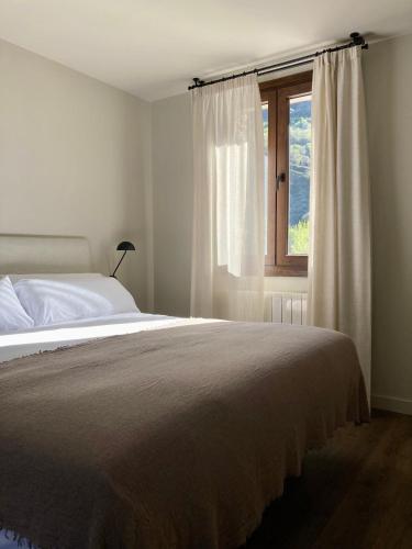 um quarto com uma cama e uma janela em Les Nous Hotel em Rialp