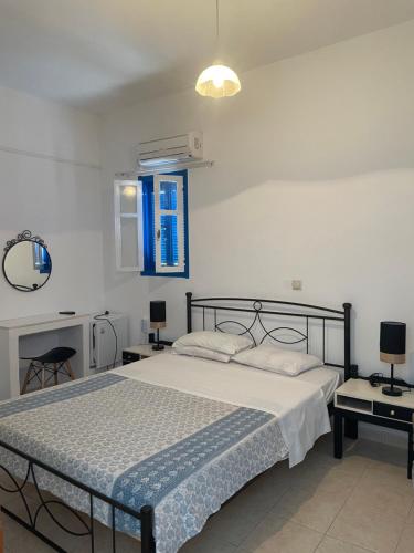 a bedroom with a bed and a blue window at Nikos Hotel in Diafani