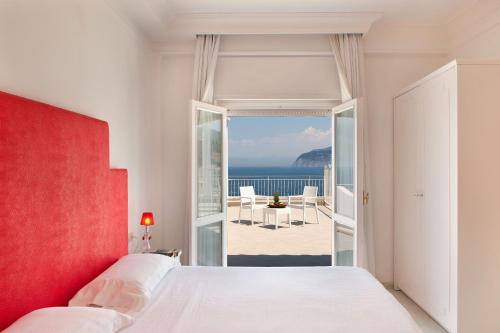 a bedroom with a bed and a view of the ocean at Hotel Admiral in Sorrento