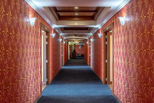 a corridor in a building with red walls at Nonthaburi Palace Hotel in Nonthaburi