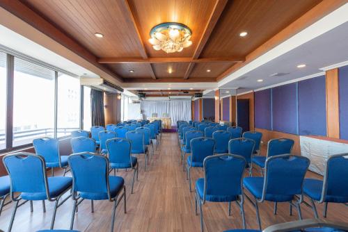 a conference room with blue chairs and a chandelier at Nonthaburi Palace Hotel in Nonthaburi