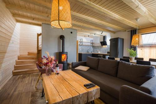 Na Jasieniu في اوسترزوكي دولن: غرفة معيشة مع أريكة وطاولة خشبية