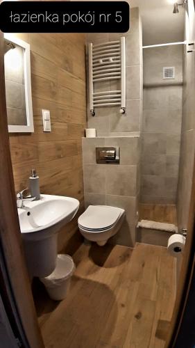 a bathroom with a white toilet and a sink at Pokoje Gościnne Gąsowscy Dzieci od 12 roku życia in Międzyzdroje