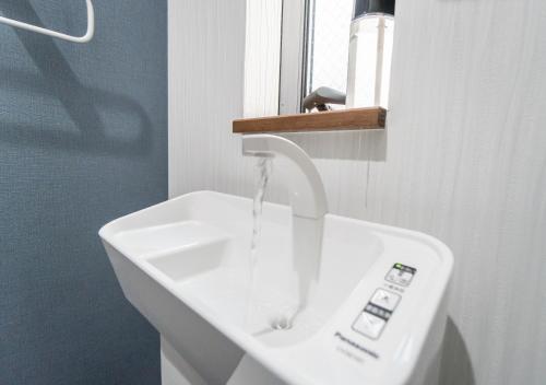 a white sink with water coming out of it at HANASTAY花渓居 · 海（UMI) in Osaka