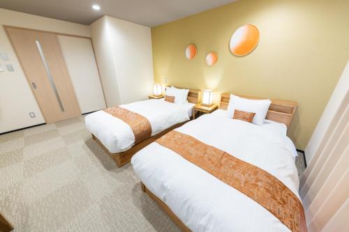 Habitación de hotel con 2 camas y 2 lámparas en Stay SAKURA Kyoto Kiyomizu Gojo, en Kioto