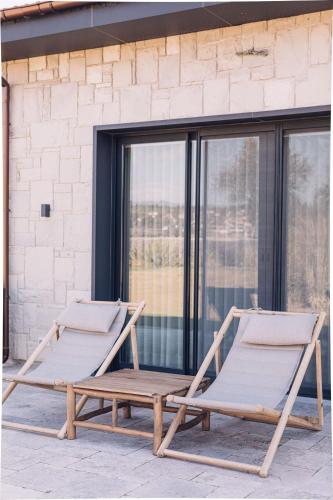 two lounge chairs on a porch with a window at Teruar Urla in Urla