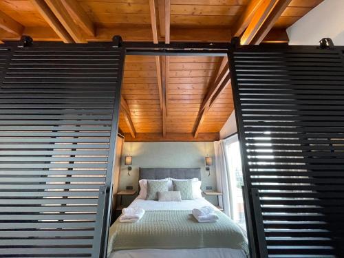 una piccola camera con letto e soffitto in legno di Apollon Loft a Calcide