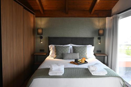 a bedroom with a large bed with towels on it at Apollon Loft in Chalkida