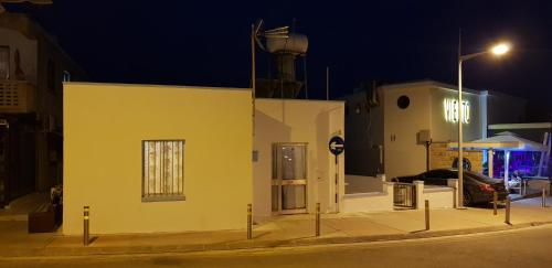 a yellow building on a street at night at Pafias Afroditis House in Paphos City