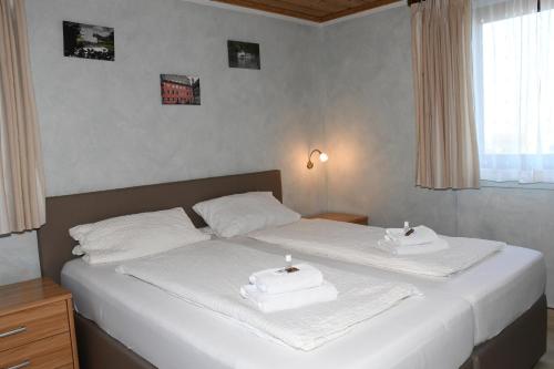 a bedroom with two beds with white towels on them at Gästehaus Zum Stehling in Monschau