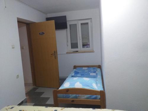 a small room with a bed and a cabinet at Apartmani Branka in Rtina